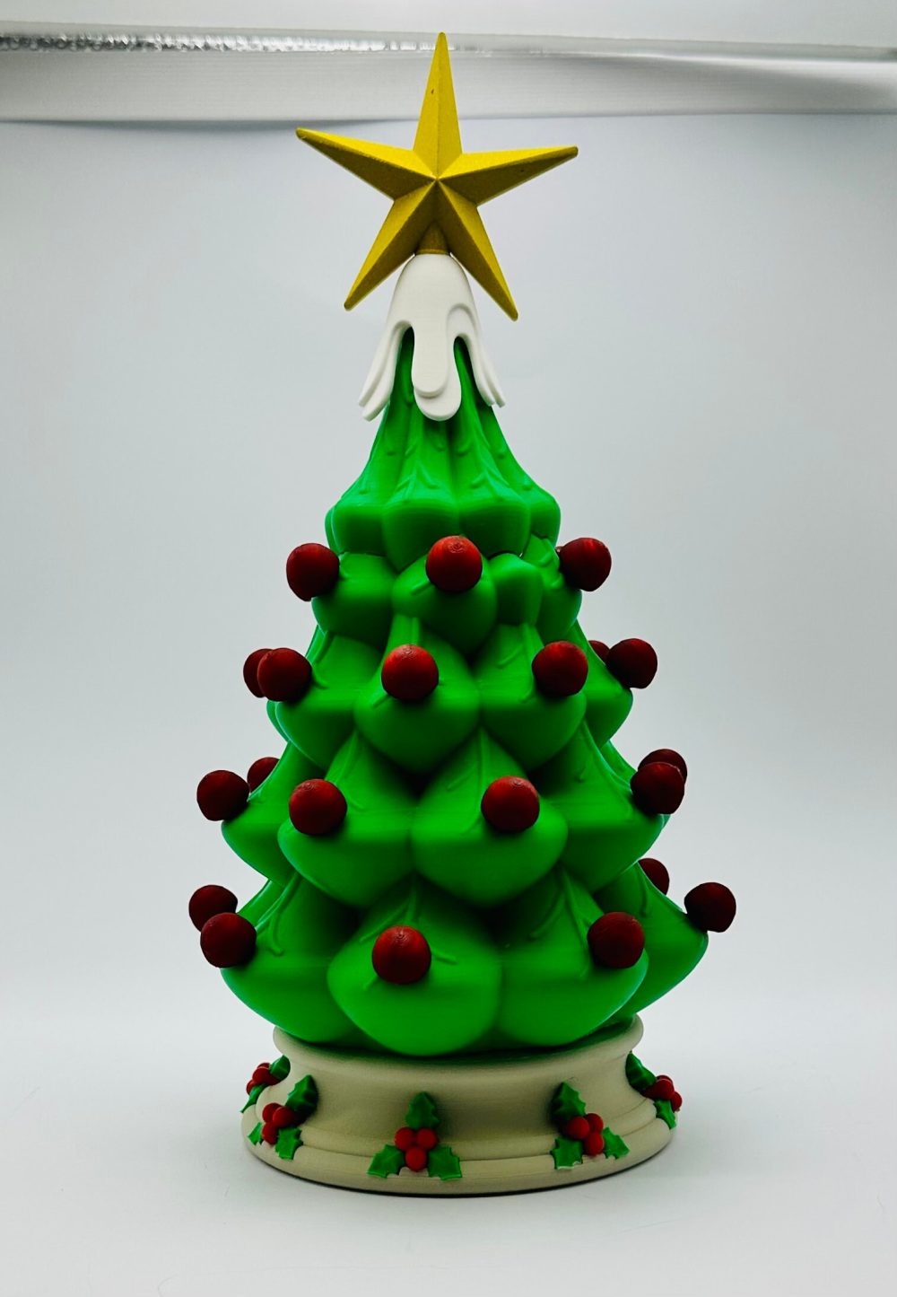 Decorative Christmas tree light with vibrant red bulbs and a yellow star on top.