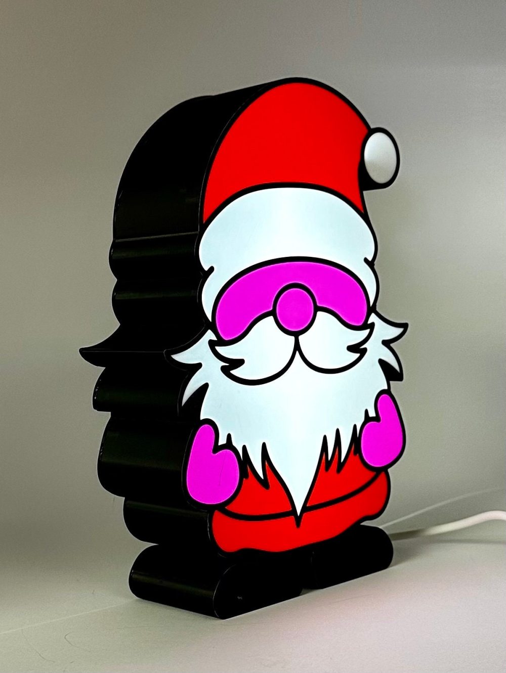 Lighted Christmas gnome decoration featuring a jolly gnome in red Santa attire with glowing elements.