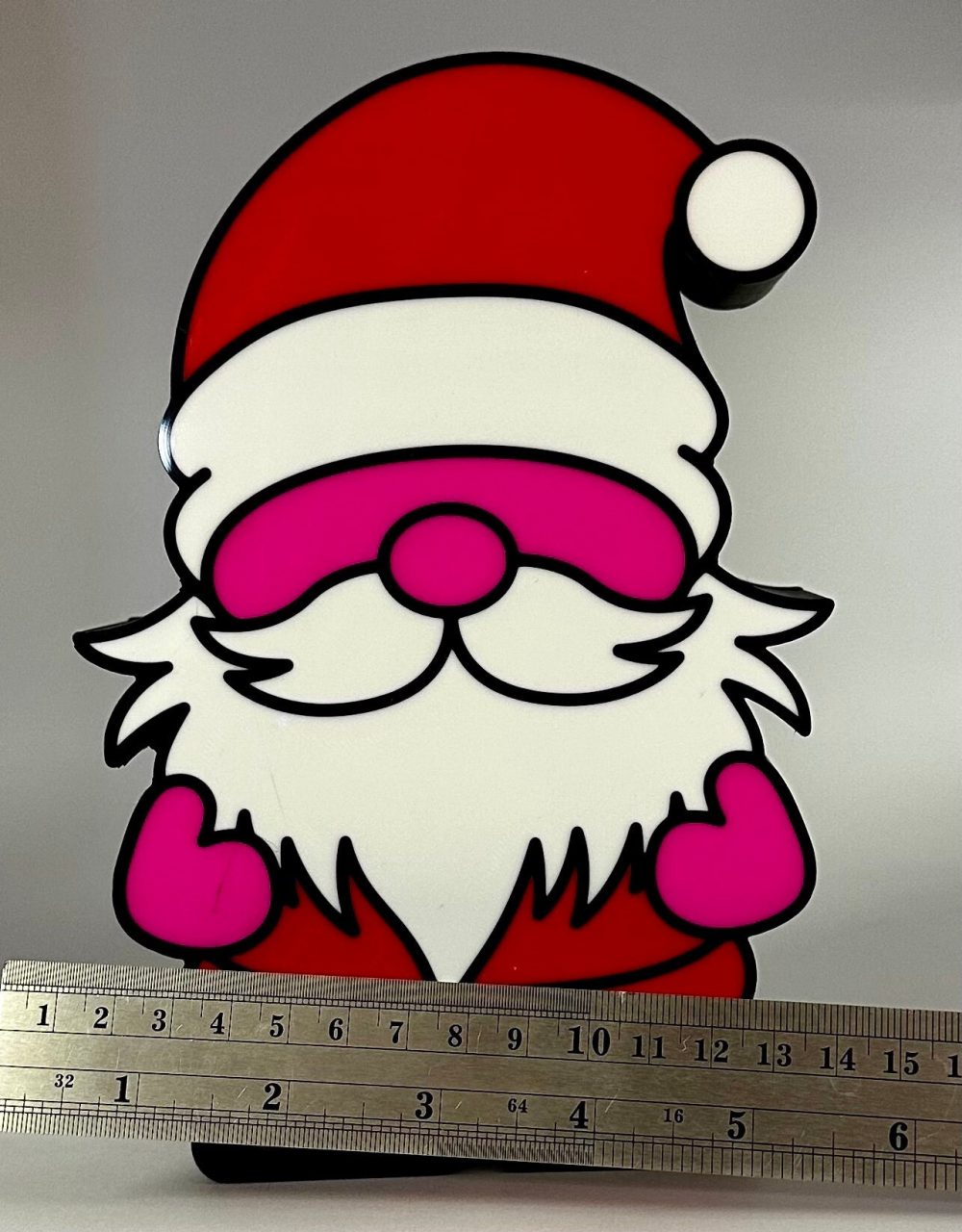 Lighted Christmas gnome decoration with a red hat and white beard, shown next to a ruler for scale.