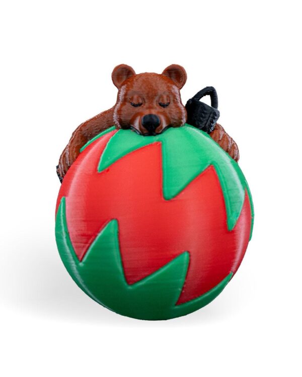 Charming Sleeping Bear Christmas Ornament: Adorable bear sleeping on a red-and-green festive ball. Handmade for holiday decor and gifts.